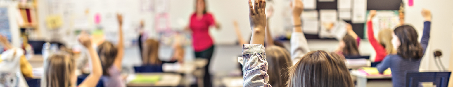 Students raising hands in a classroom